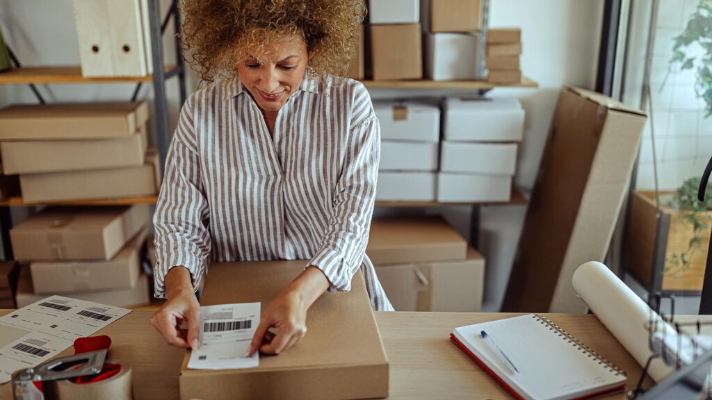 Small business owner applying a label