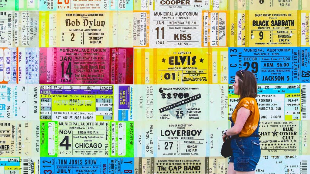 Woman walks past wall full of vintage ticket posters